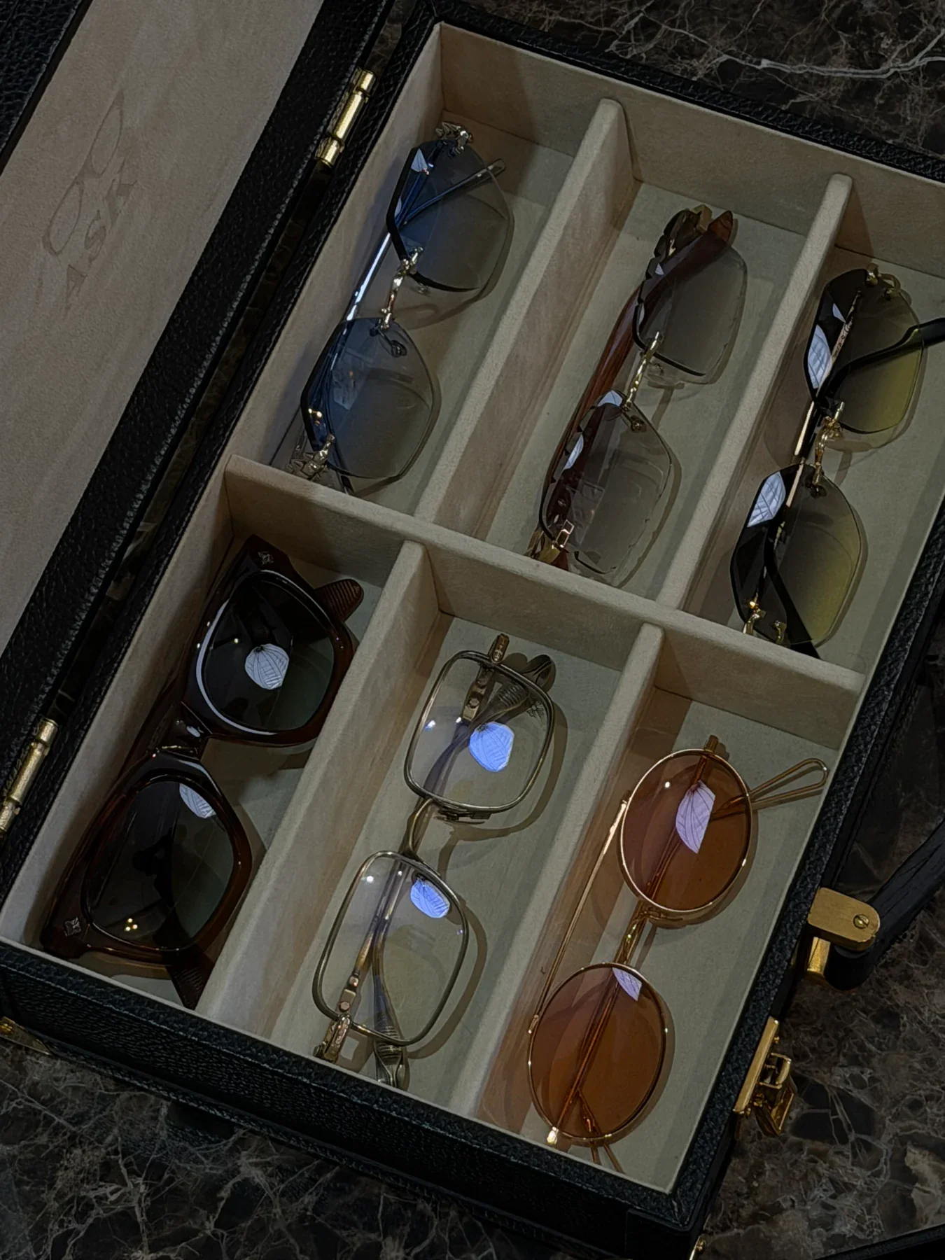 An open eyewear trunk holding ASK's collection of frames