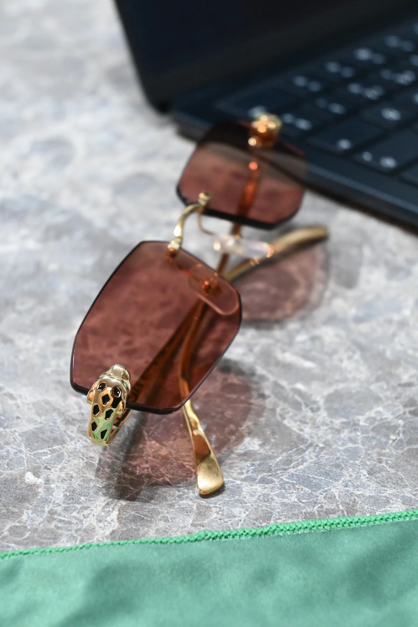 Cartier Panthère with brown lenses and a gold-tone panther detail, photographed by ASK on marble