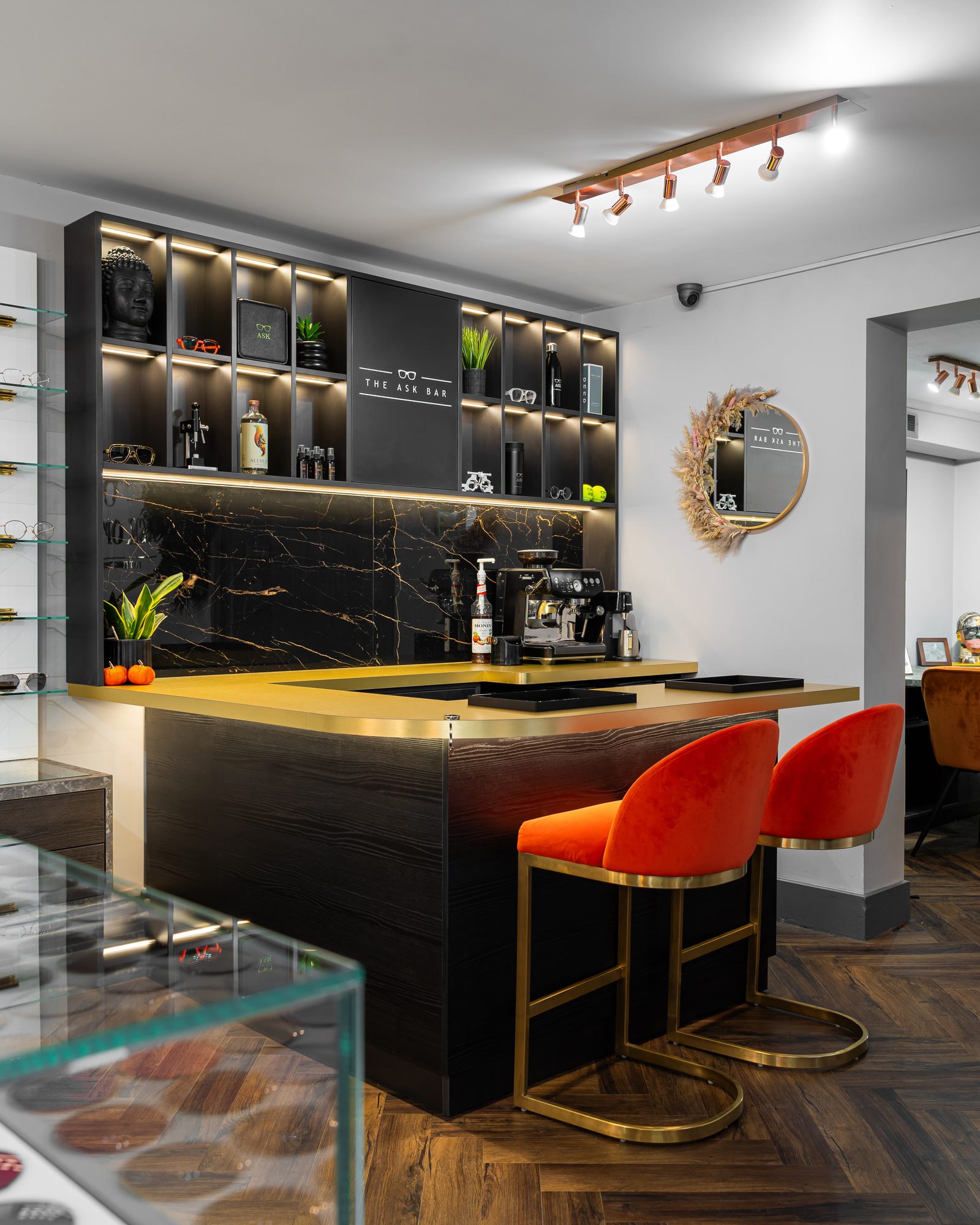 The ASK Bar, with its red velvet stools and lit shelves