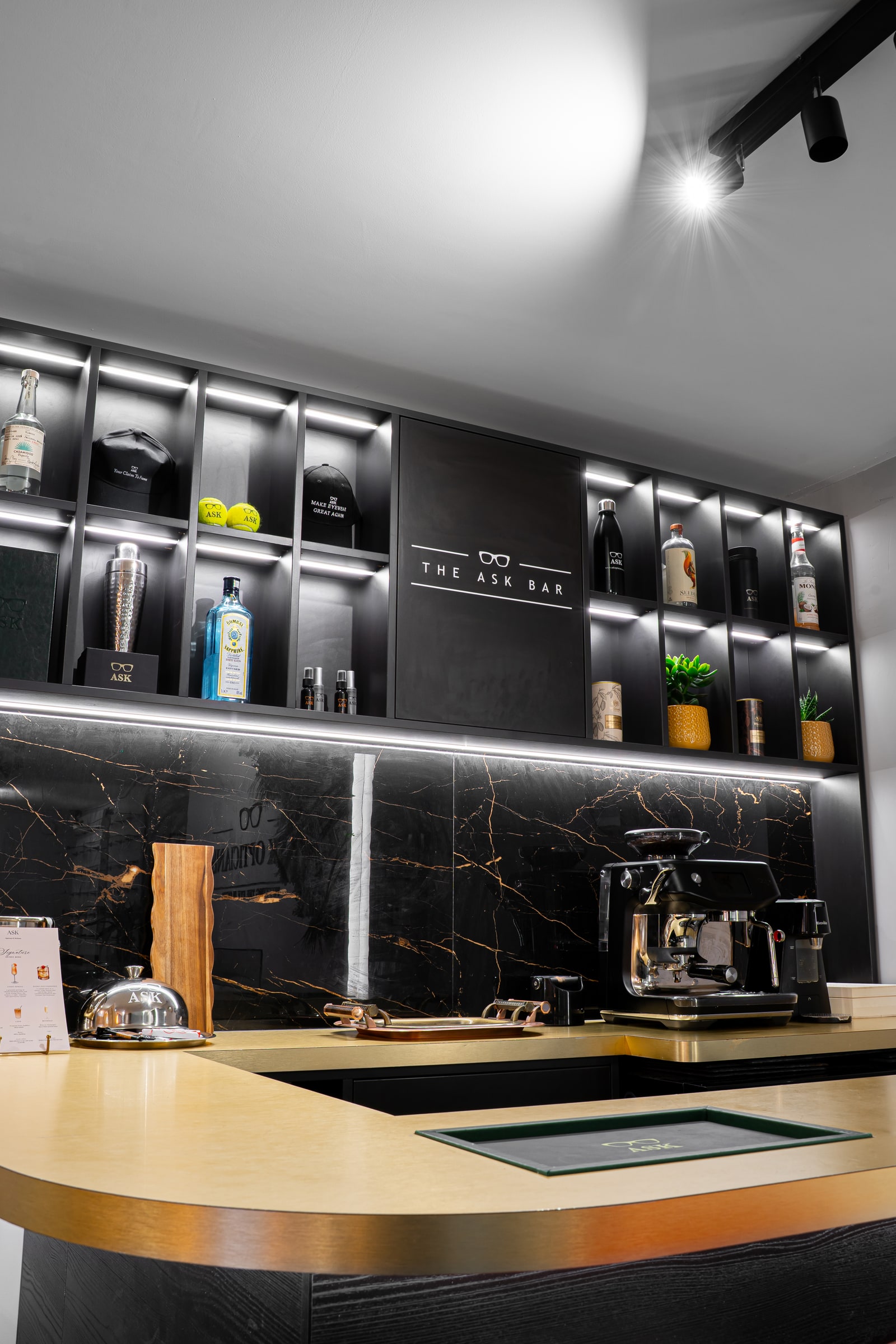 The illuminated shelves, coffee machine and counter at the ASK Bar