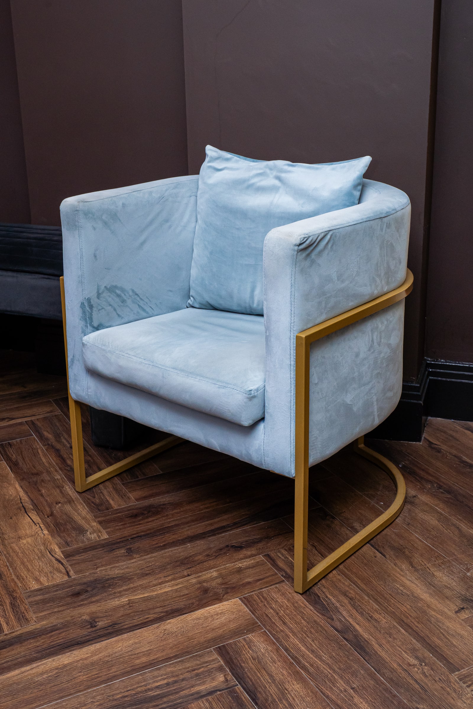 The blue velvet chair with its brass frame at ASK