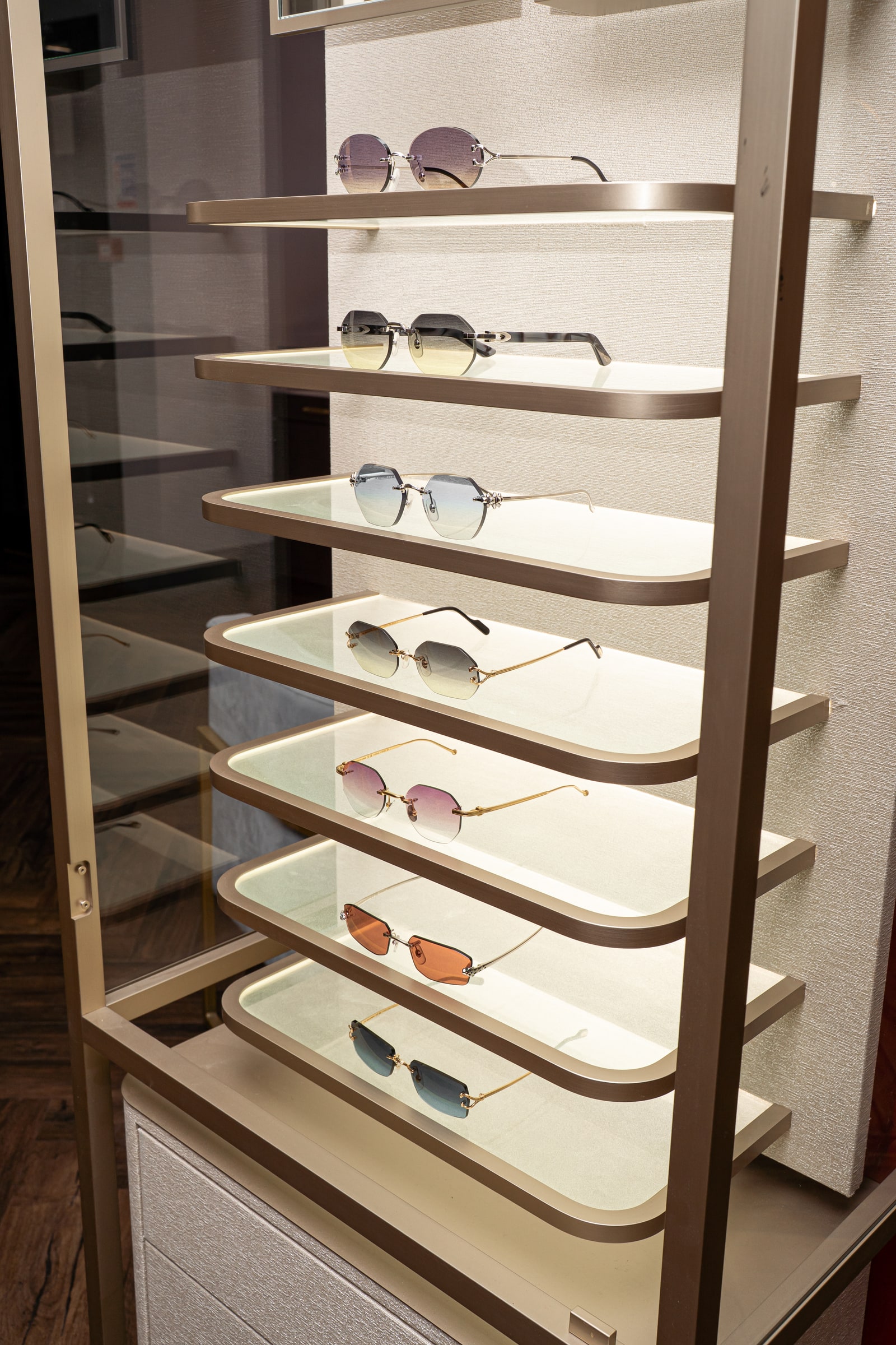 Cartier frames with different lens shapes and tints in the illuminated cabinet