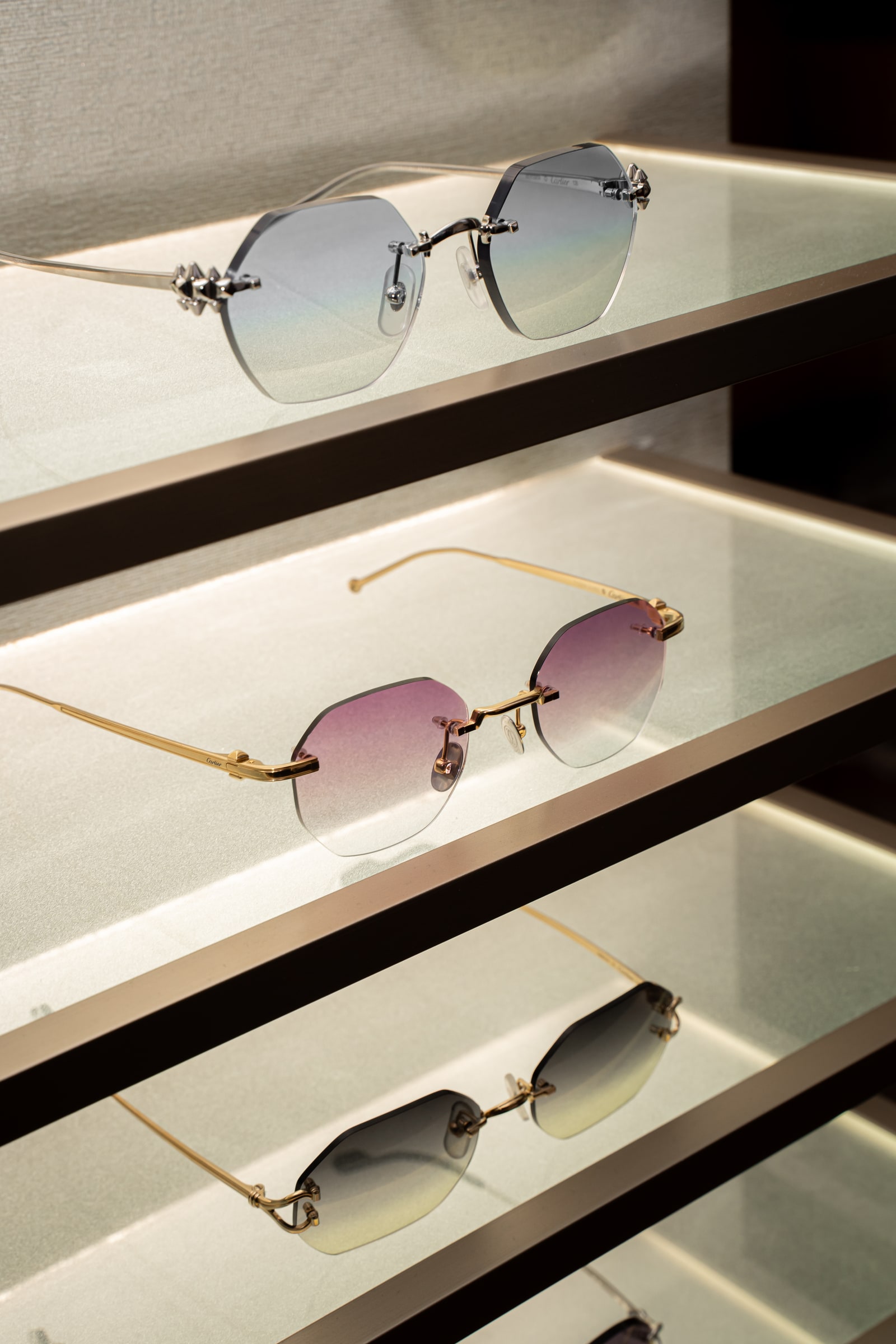 Cartier frames with different lens tints on the illuminated display shelves