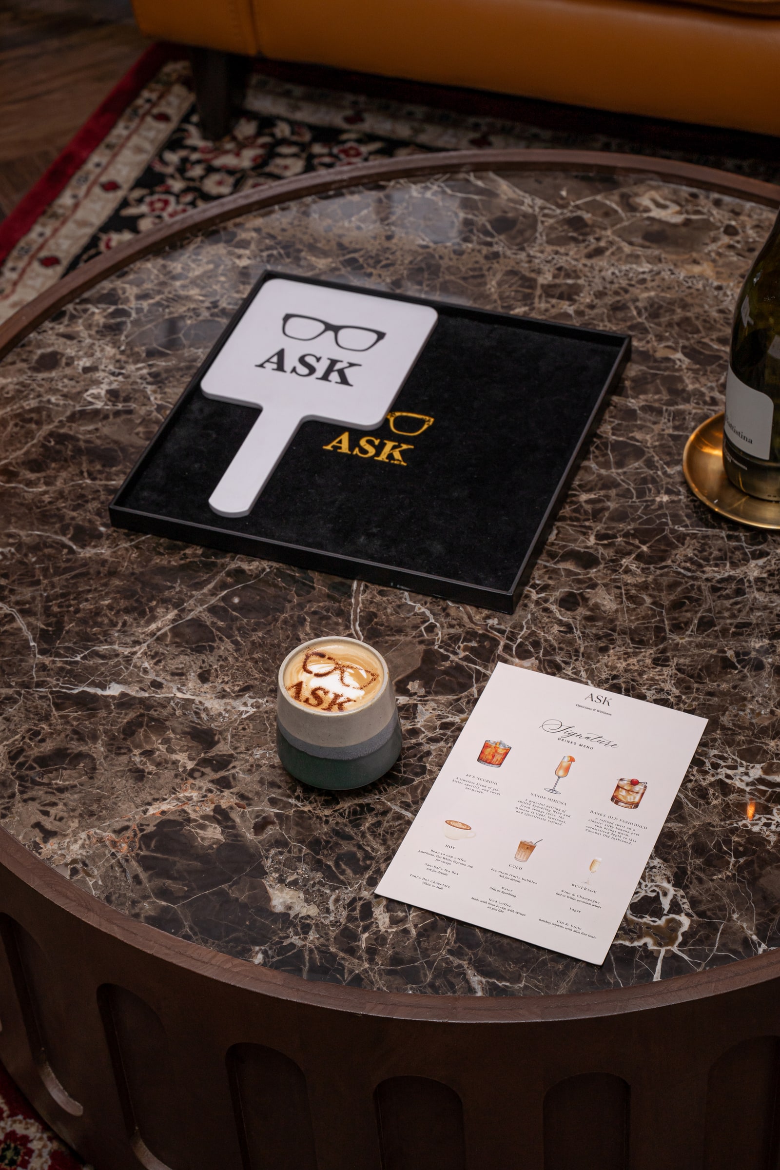 An ASK mirror, coffee and drinks menu on the marble lounge table