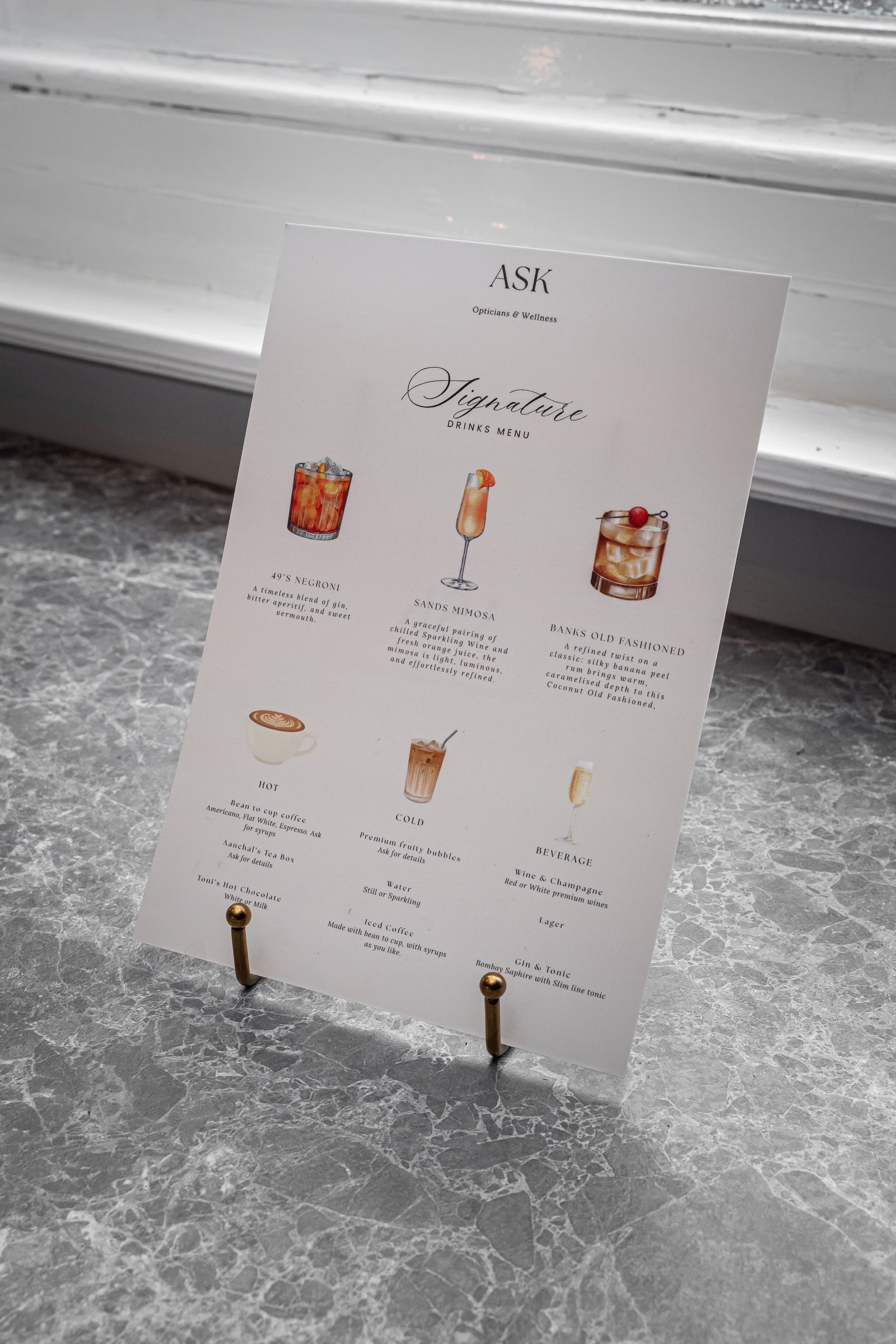 The ASK signature drinks menu on a marble table