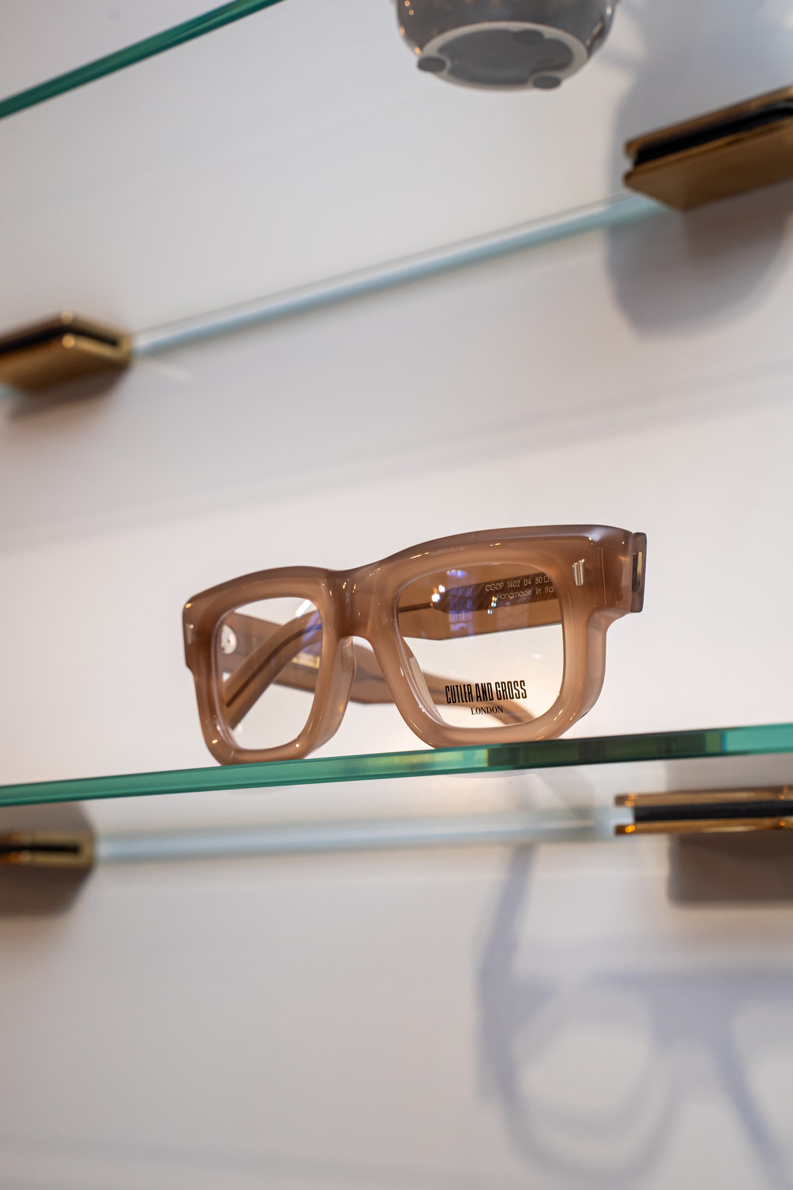 An optical frame on an illuminated glass display shelf at ASK