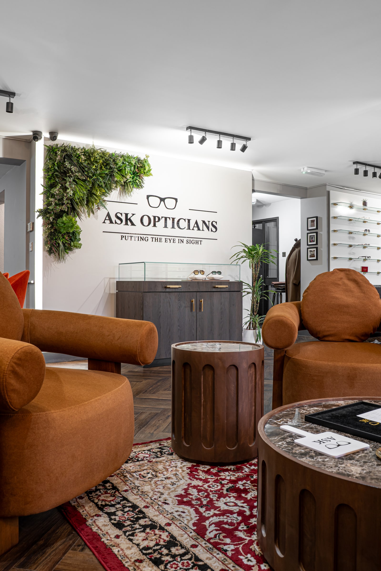 The ASK wall sign seen from the brown lounge chairs and marble tables