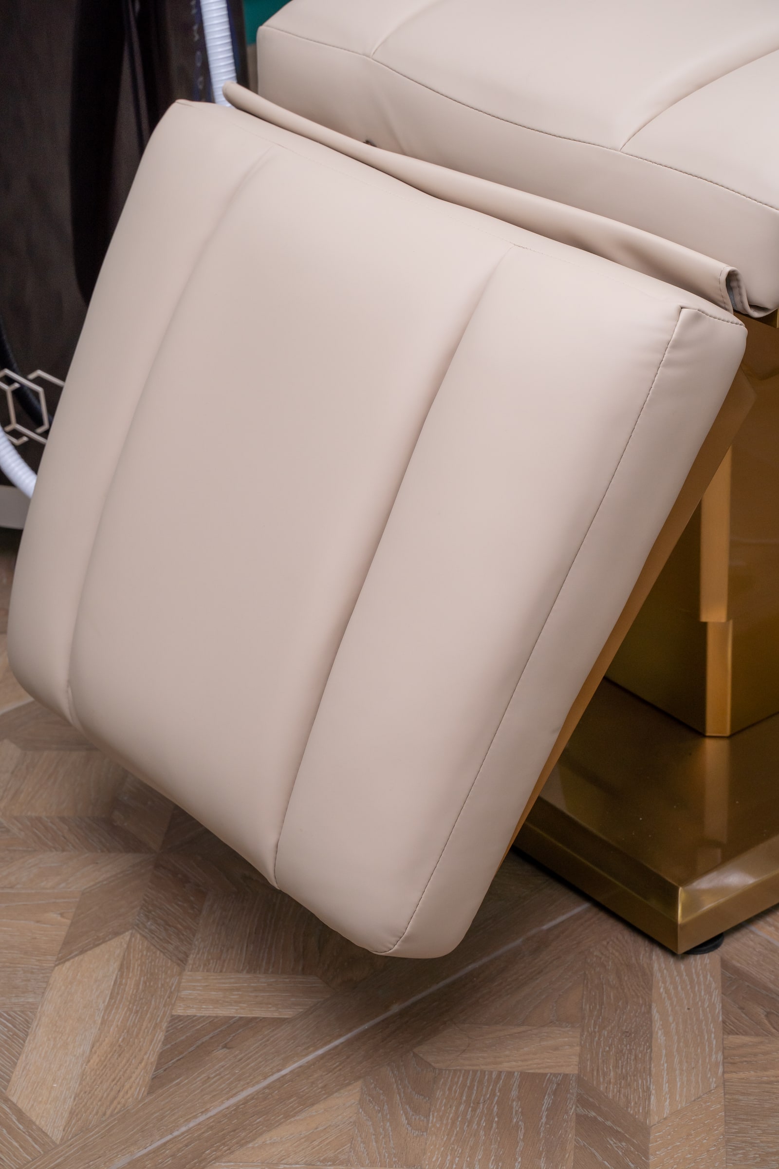 A close view of the cream upholstery and footrest of the wellness treatment chair