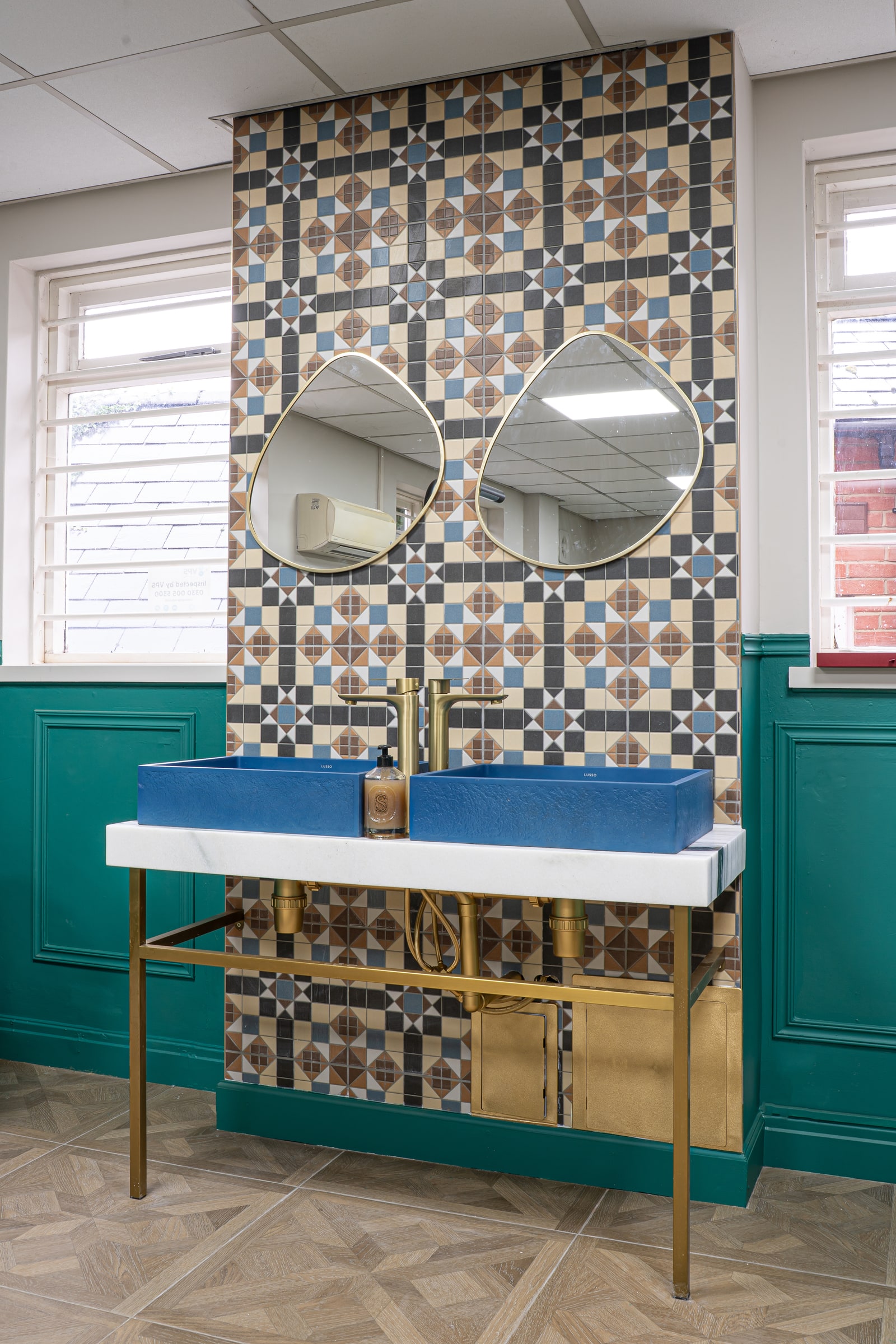 Blue basins, brass taps and patterned tiles in the ASK washroom