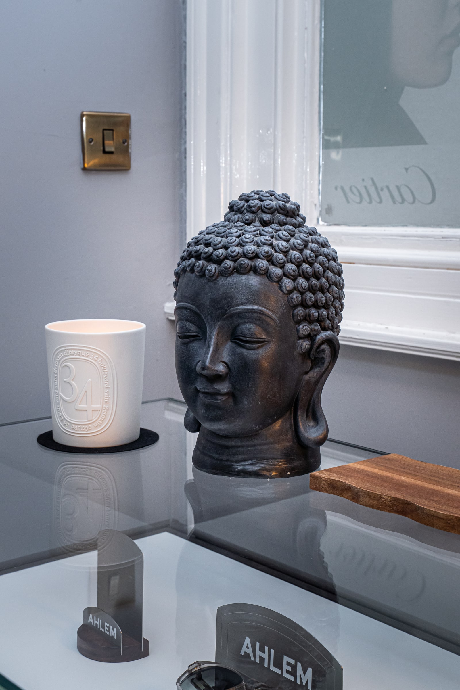 A sculpted ornament and candle beside the AHLEM display at ASK